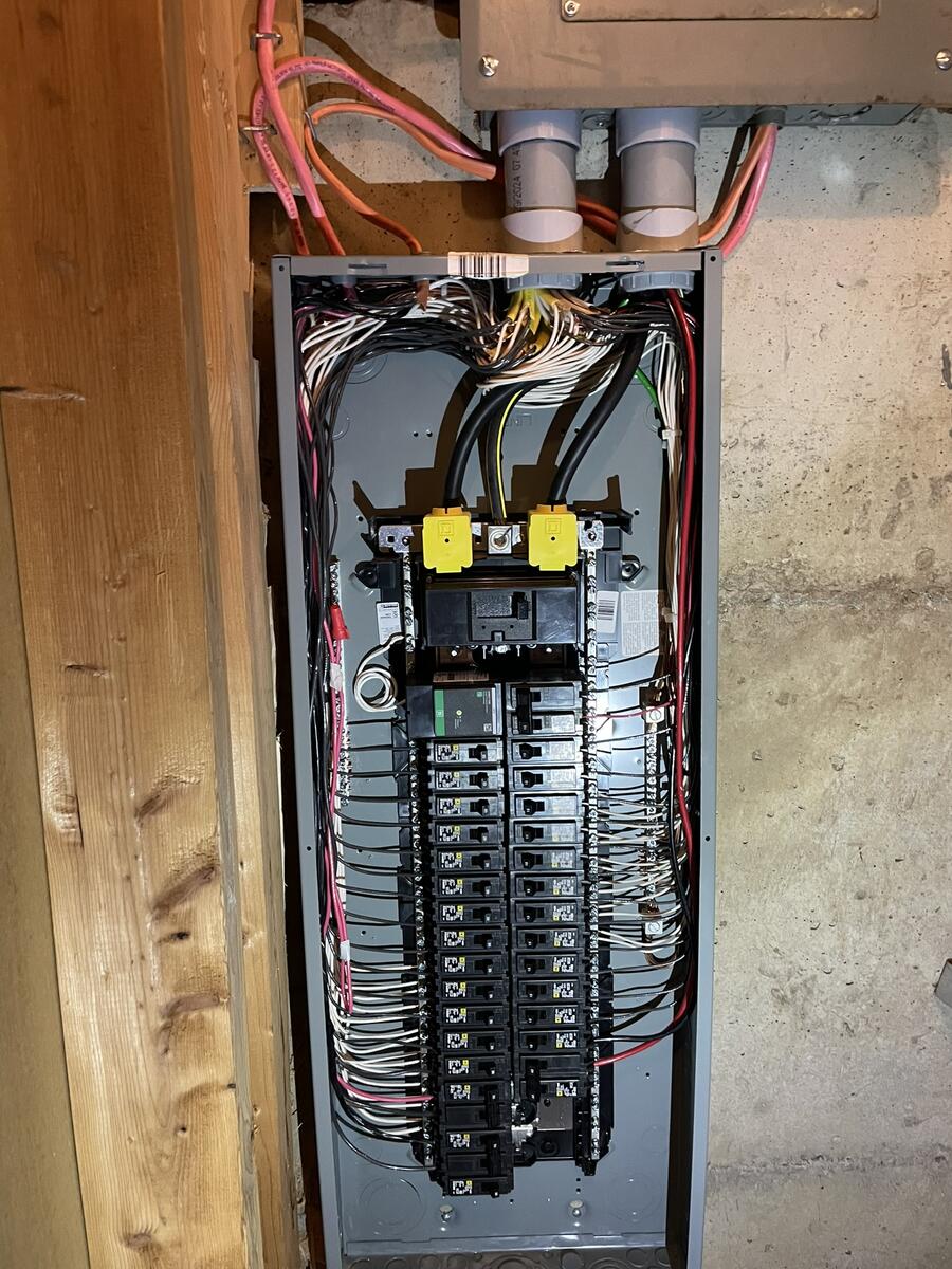 Completed electrical panel upgrade with new breakers and labeling